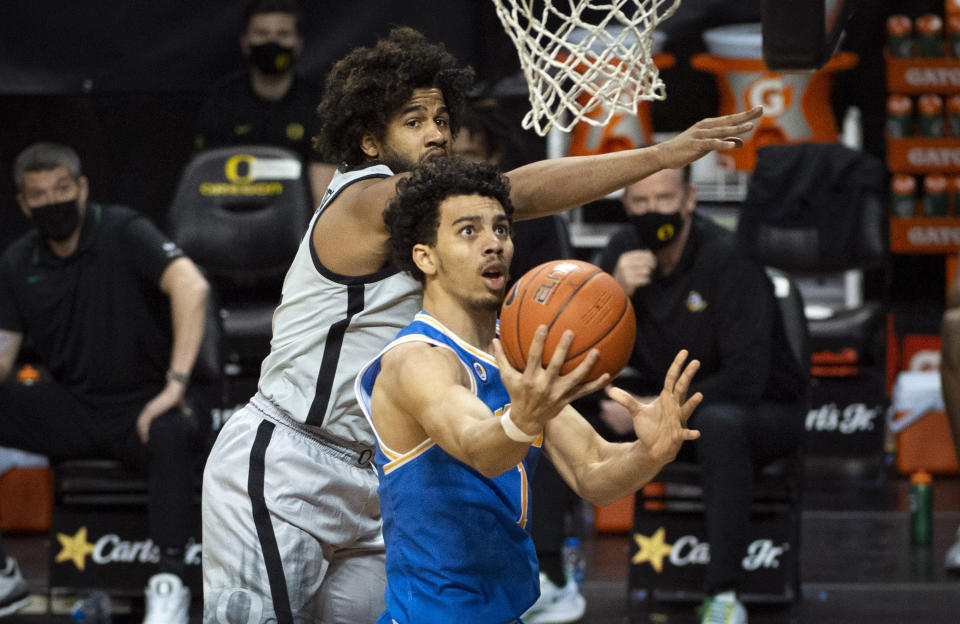 UCLA guard Jules Bernard (1) drives past Oregon guard LJ Figueroa (12) during the first half of an NCAA college basketball game Wednesday, March 3, 2021, in Eugene, Ore. (AP Photo/Andy Nelson)