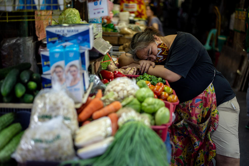 A vendor wearing protective face mask rests in front of her store at a public market in Pasig City, Philippines on August 4, 2020. (Photo by Lisa Marie David/NurPhoto via Getty Images)