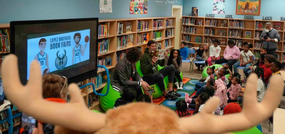 Milwaukee Bucks mascot Bango watches and listens as the Lopez brothers, Brook and Robin, of the Bucks, read to students in addition to hosting a Scholastic Book Fair Wednesday at Auer Avenue Elementary School, allowing each student to select five new books.