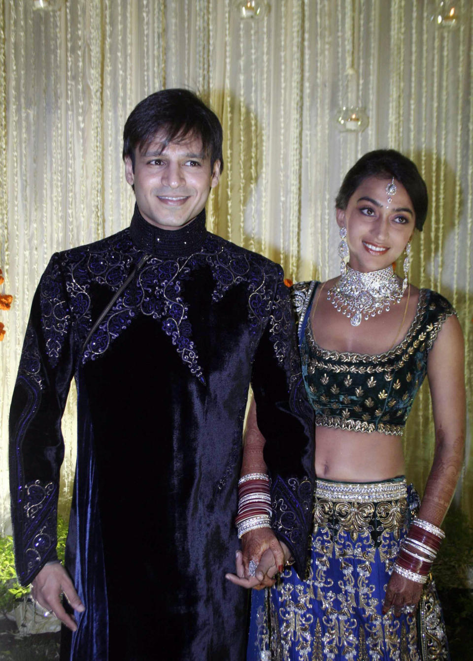 Indian Bollywood actor Vivek Oberoi (L) recently married Priyanka Alva (R) pose at a reception party late night October 31, 2010 in Mumbai. AFP PHOTO/STR (Photo credit should read STRDEL/AFP via Getty Images)