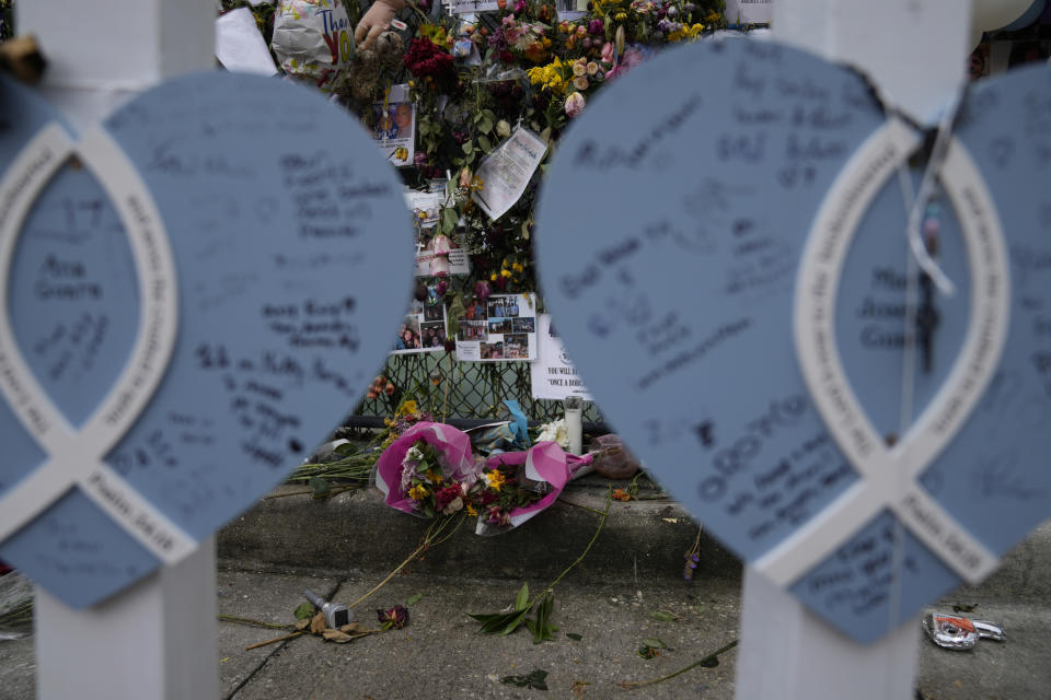 Flowers, photographs, and messages of love decorate a rain-soaked memorial for the victims of the Champlain Towers South building collapse, on Monday, July 12, 2021, in Surfside, Fla.(AP Photo/Rebecca Blackwell)