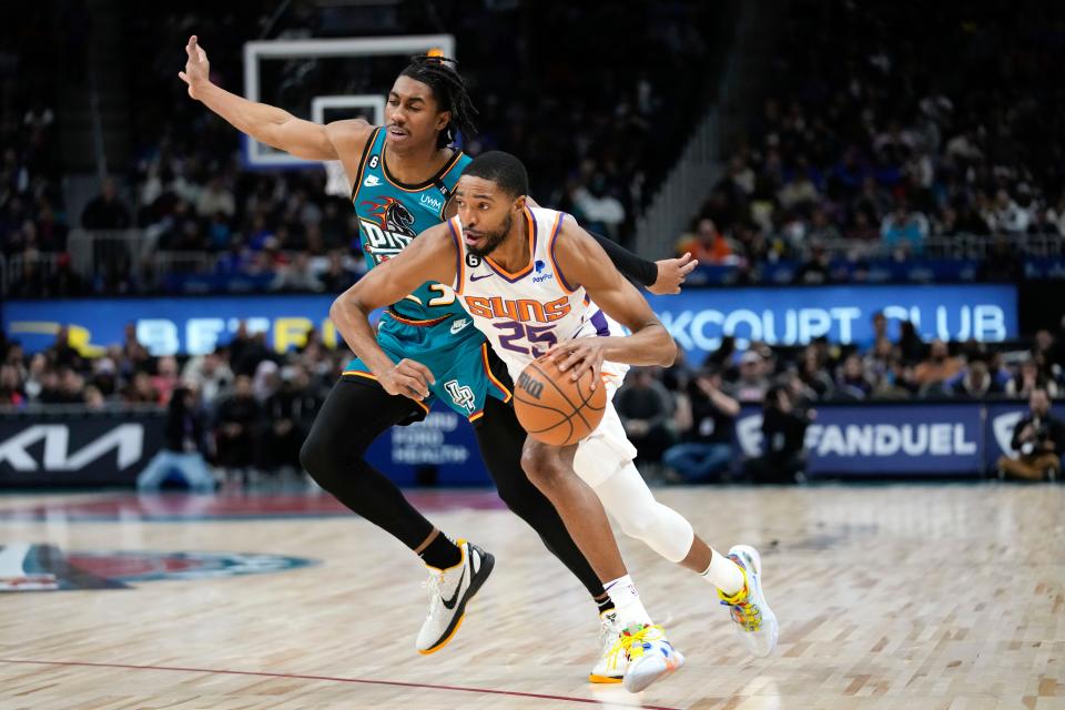 Phoenix Suns forward Mikal Bridges (25) drives on Detroit Pistons guard Jaden Ivey (23) in the first half of an NBA basketball game in Detroit, Saturday, Feb. 4, 2023. (AP Photo/Paul Sancya)