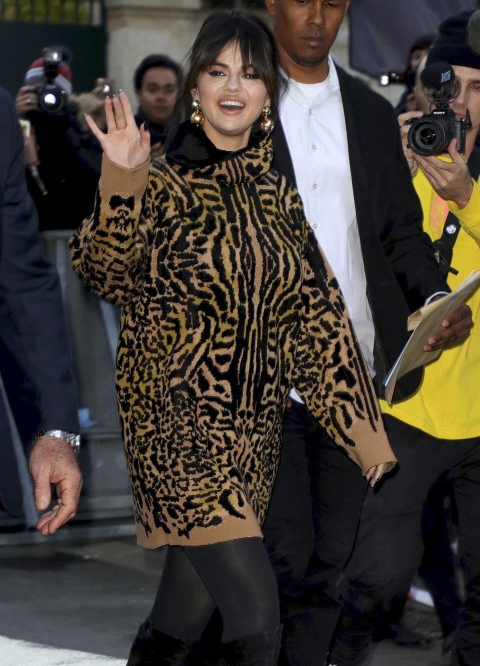 Selena Gomez waves to fans while leaving the NRJ radio station studios on Friday in Paris.