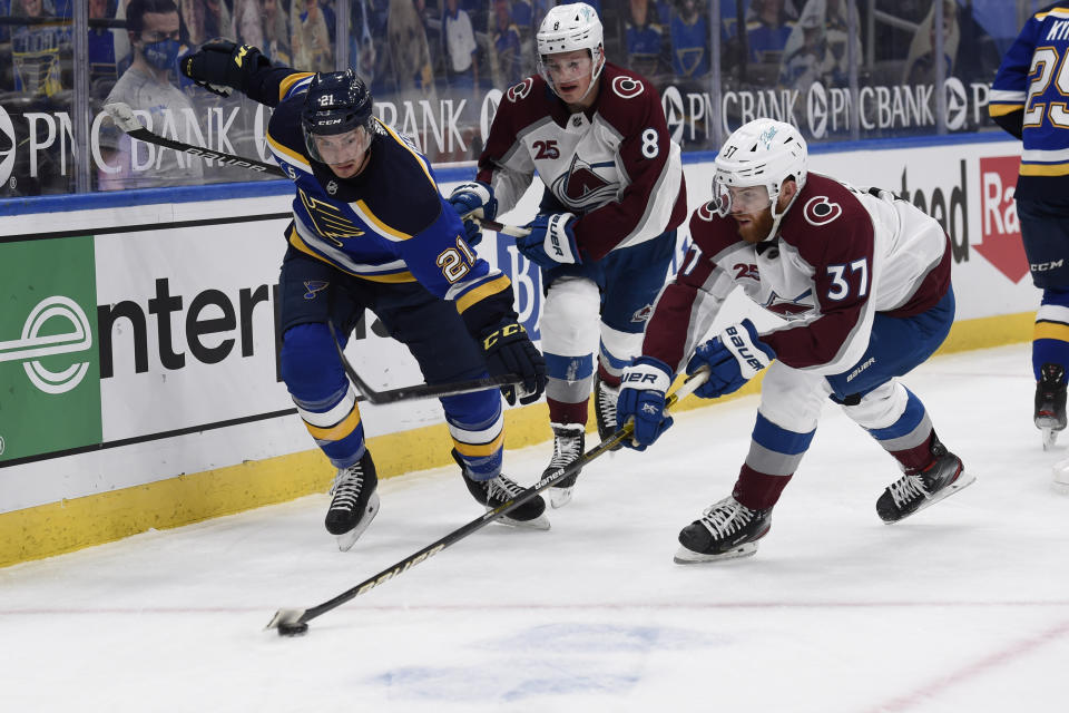 St. Louis Blues' Tyler Bozak (21) and Colorado Avalanche's J.T. Compher (37) battle for the puck during the second period of an NHL hockey game on Wednesday, April 14, 2021, in St. Louis. (AP Photo/Joe Puetz)