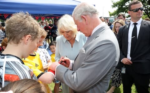 Prince Charles signs a young boy's plaster cast at the market - Credit: &nbsp;Chris Jackson/Chris Jackson