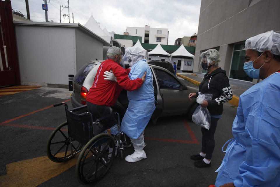 A health worker helps Luis Reyes into a car, to be taken home after recovering from COVID-19, outside the Mexico City Ajusco Medio General Hospital, Wednesday, Dec. 2. 2020. Mexico continues to report an increase in the number of coronavirus cases, with Mexico City continuing to report the biggest portion of the surge. (AP Photo/Marco Ugarte)