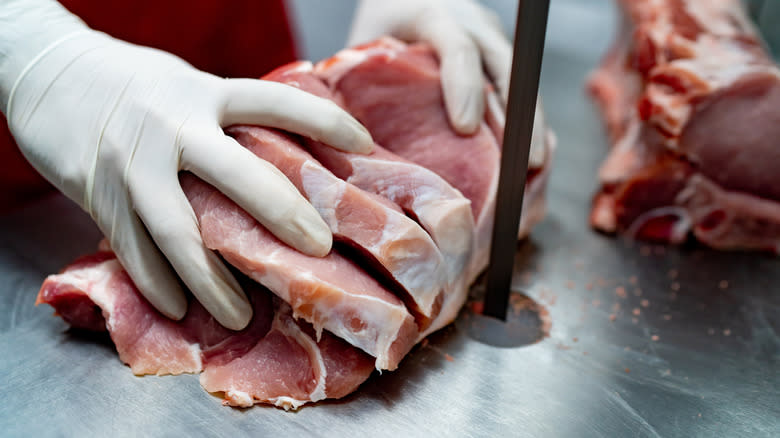 Raw pork being cut