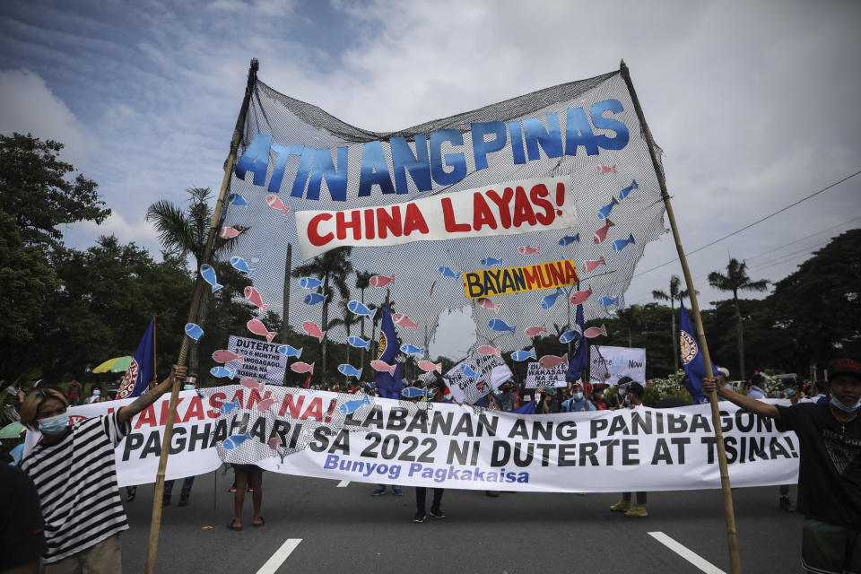 Protesters hold a slogan that reads "Philippines is ours, China get out!" as they tried to march towards the House of Representative where Philippine President Rodrigo Duterte is set to deliver his final State of the Nation Address in Quezon city, Philippines on Monday, July 26, 2021. Duterte is winding down his six-year term amid a raging pandemic and a battered economy. (AP Photo/Gerard Carreon)