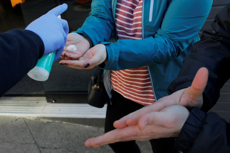 FILE PHOTO: Customers are given hand sanitizer before being allowed to enter The Reef Cannabis shop in Seattle