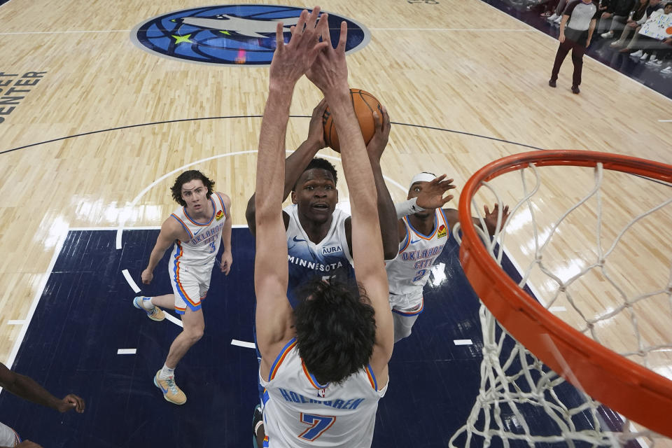 Minnesota Timberwolves guard Anthony Edwards, center top, goes up to shoot as Oklahoma City Thunder forward Chet Holmgren (7) defends during the second half of an NBA basketball game, Saturday, Jan. 20, 2024, in Minneapolis. (AP Photo/Abbie Parr)