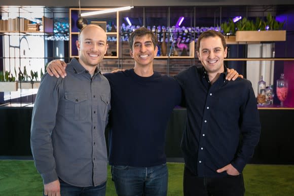 The three men are shown standing arm-in-arm at Lyft's headquarters.