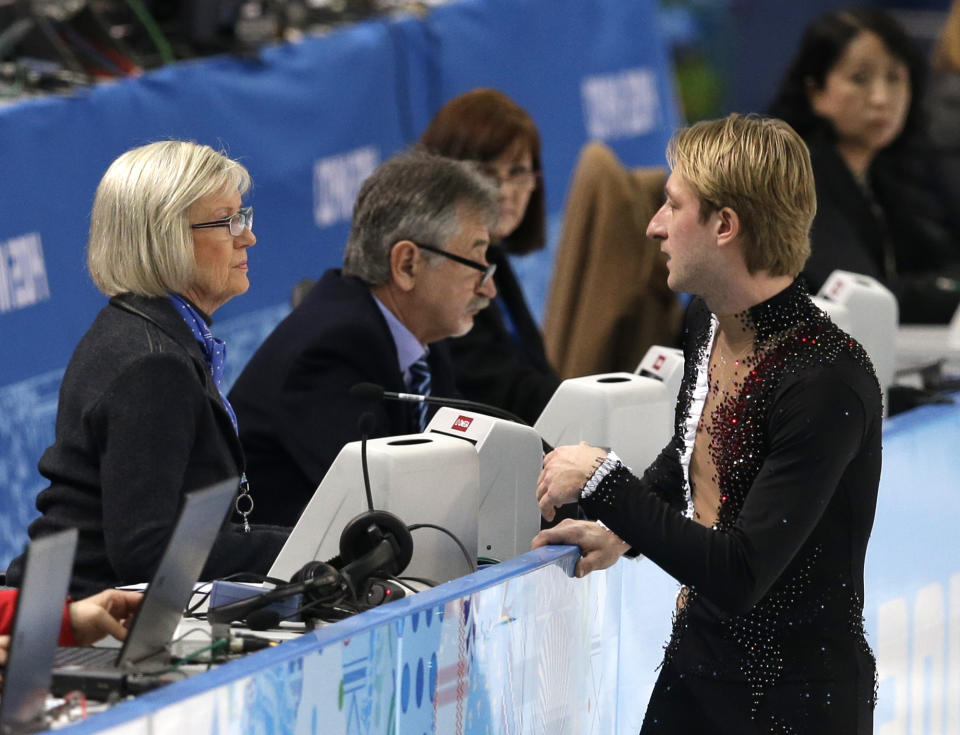 Evgeni Plushenko of Russia speaks with an official prior to pulling out of the men's short program figure skating competition due to illness at the Iceberg Skating Palace during the 2014 Winter Olympics, Thursday, Feb. 13, 2014, in Sochi, Russia. (AP Photo/Darron Cummings)