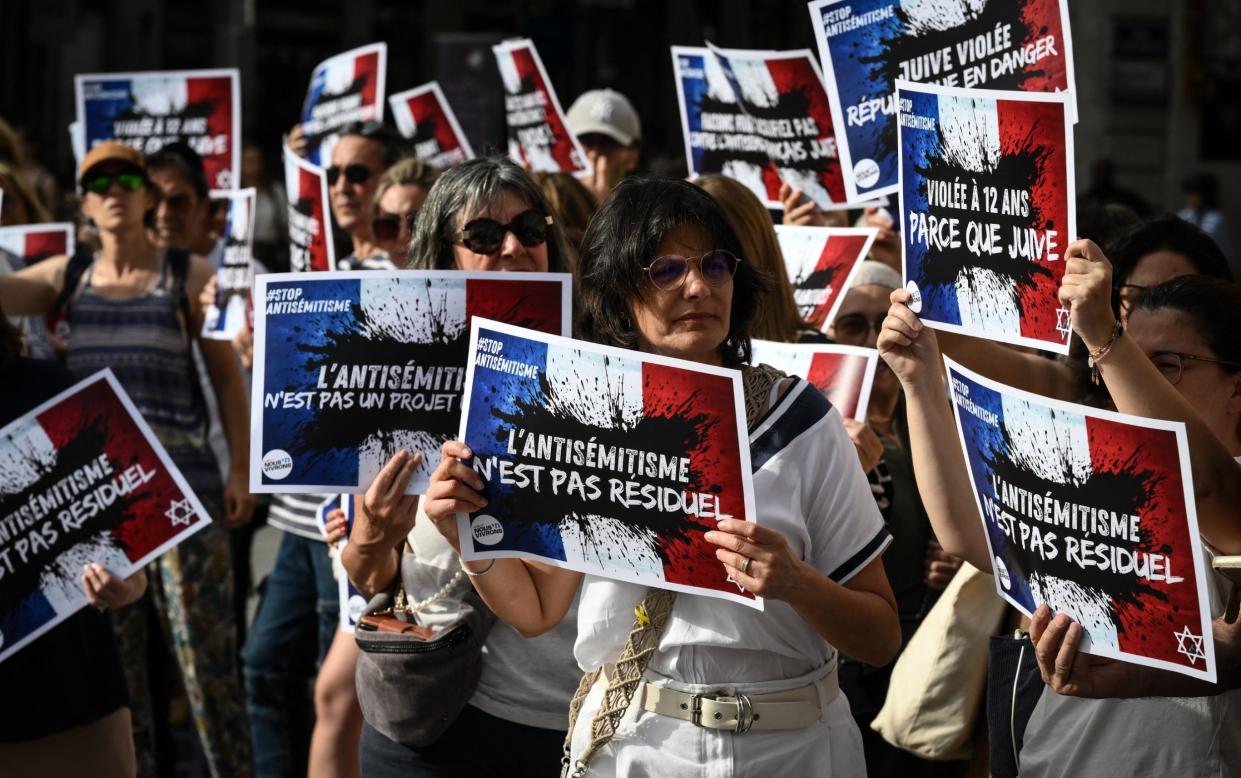 Protesters hold placards condemning anti-Semitism and highlighting the rape at a demonstration in Lyon on Wednesday