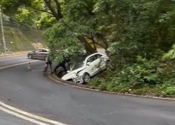 白色私家車意外後剷入草叢。
