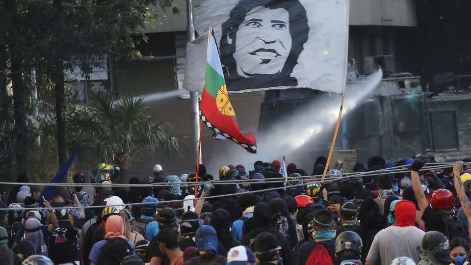 Demonstrators carry a flag with Victor Jara's image during a protest against the Chilean government in January 2020. - Marcelo Hernandez/Getty Images