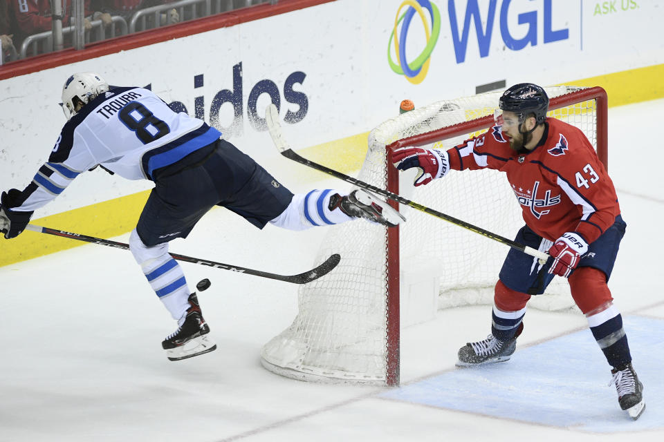 Winnipeg Jets defenseman Jacob Trouba (8) chases after the puck past Washington Capitals right wing Tom Wilson (43) during the third period of an NHL hockey game, Sunday, March 10, 2019, in Washington. The Capitals won 3-1. (AP Photo/Nick Wass)