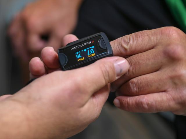 Dr. Joe Holbrook uses a blood oxygen monitor on the hand of his patient Richard Champion, inside the HANDS Clinic mobile healthcare van Thursday, March 16, 2023, in Fort Pierce.