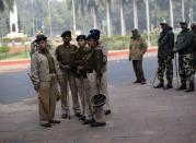 Police watch as supporters of Rashtrawadi Shiv Sena, a Hindu hardline group, take part in a protest near the U.S. embassy in New Delhi December 18, 2013. Indian police removed concrete security barriers outside the U.S. Embassy in New Delhi on Tuesday in apparent retaliation for the treatment of an Indian diplomat who was strip-searched after her arrest in New York last week. The diplomatic spat was triggered by the December 12 arrest of Devyani Khobragade, a deputy consul general at the Indian Consulate in New York, on charges of visa fraud and making false statements for allegedly lying about how much she paid her housekeeper, an Indian national. (REUTERS/Ahmad Masood)