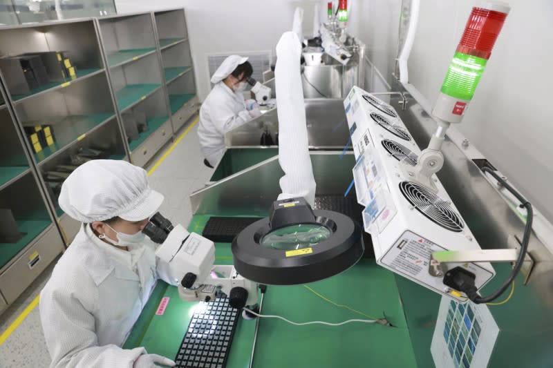 <cite>中國江蘇一家電路封裝測試工廠，工人正在進行檢查。（美聯社）</cite>