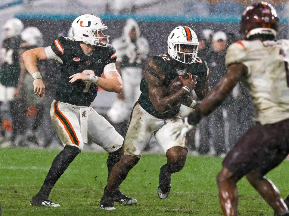 Miami Hurricanes quarterback Tyler Van Dyke (9) hand off to running back Thaddius Franklin Jr. (22) during the fourth quarter of their ACC football game against the Virginia Tech Hockies at Hard Rock Stadium on Saturday, November 20, 2021 in Miami Gardens, Florida.