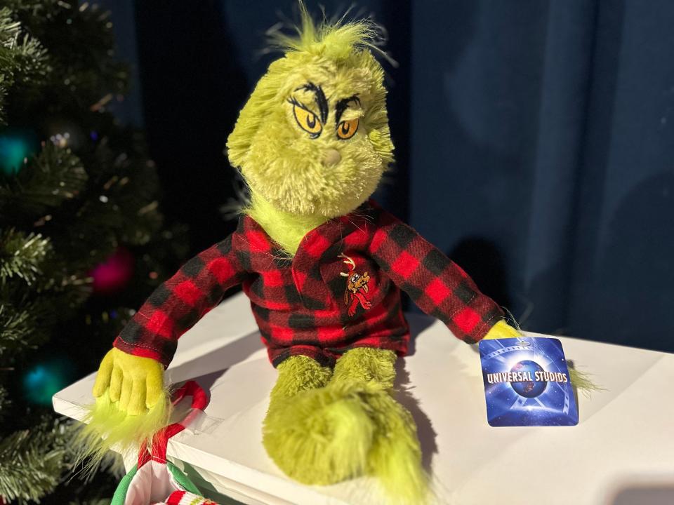 Stuffed Grinch plushie in a plaid shirt from universal studios