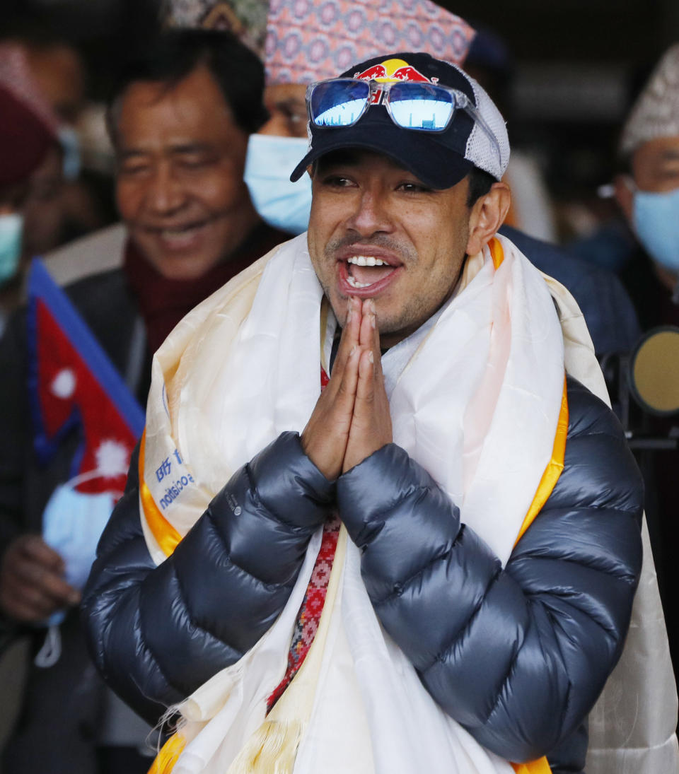 Nirmal Purja, one of the team member of the all-Nepalese mountaineering team that became the first to scale Mount K2 in winter greets as the team arrives at Tribhuwan International airport in Kathmandu, Nepal, Tuesday, Jan. 26, 2021. (AP Photo/Niranjan Shrestha)