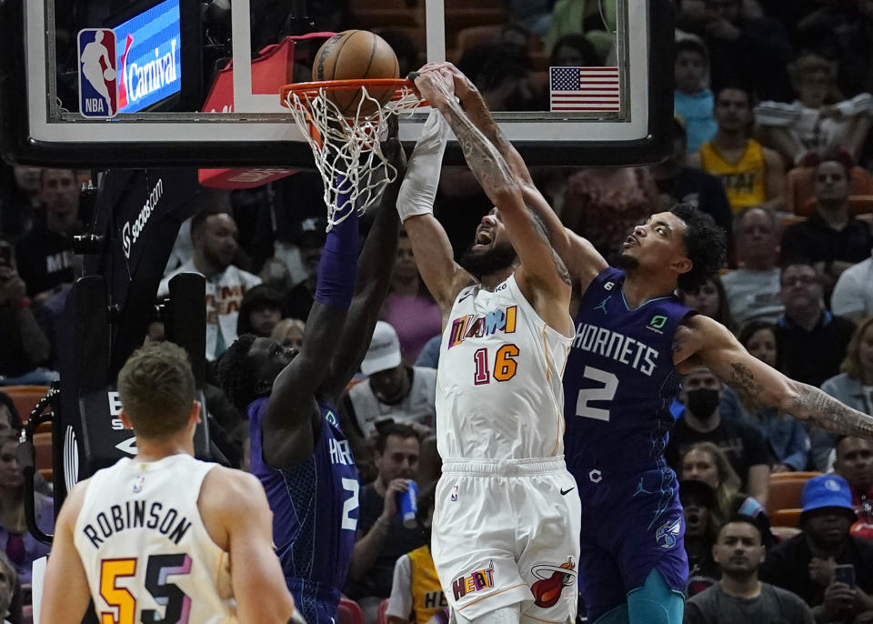 Miami Heat forward Caleb Martin (16) drives to the basket as Charlotte Hornets guard James Bouknight (2) and forward JT Thor (21) defend during the first half of an NBA basketball game Thursday, Nov. 10, 2022, in Miami. (AP Photo/Marta Lavandier)