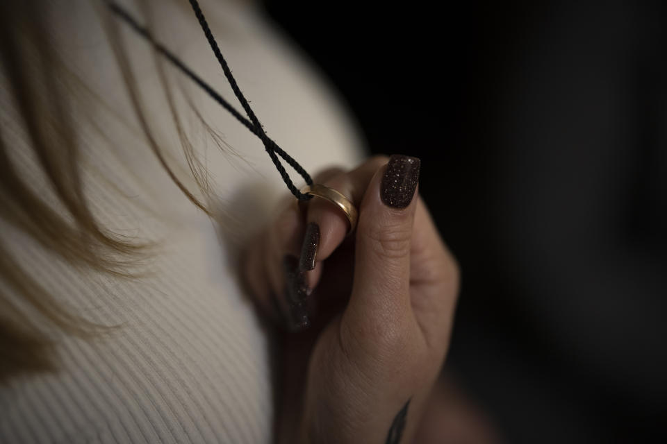 Anastasiia Okhrimenko holds the wedding ring given to her by her late husband, Yurii Stiahliuk, at her home in Bucha, Ukraine, Sunday, Jan. 22, 2023. (AP Photo/Daniel Cole)