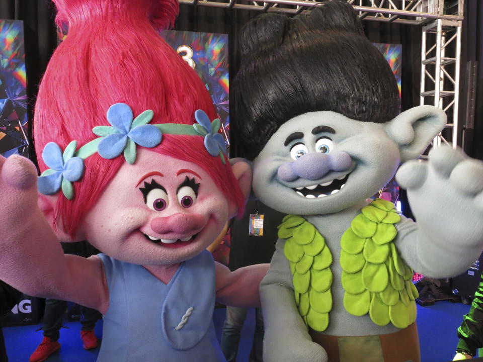 Personas con disfraces de los personajes animados Poppy, izquierda, y Branch en la alfombra roja de la película Trolls Band Together en la Ciudad de México el domingo 15 de octubre de 2023. (Foto AP/Berenice Bautista)