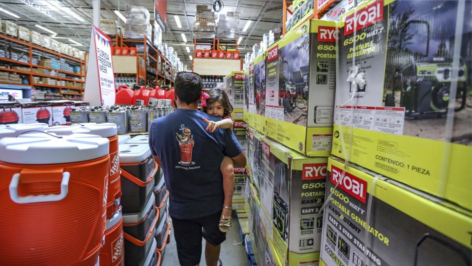 Frank Barakat carries his daughter Valentina, 2, through an shopping aisle dedicated for hurricane supplies as the Home Depot store prepares for possible effects of tropical storm Elsa in Miami on Saturday, July 3, 2021. Elsa fell back to tropical storm force as it brushed past Haiti and the Dominican Republic on Saturday and threatened to unleash flooding and landslides before taking aim at Cuba and Florida. (Al Diaz/Miami Herald via AP)