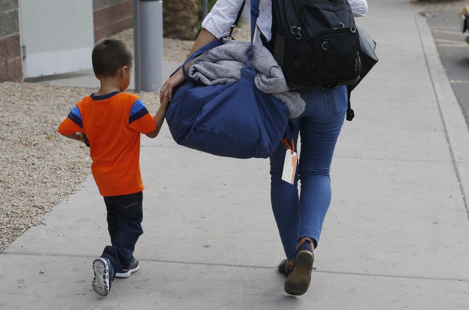 In this July 10, 2018, photo, 3-year-old Jose Jr. from Honduras is helped by a representative of the Southern Poverty Law Center as he is reunited with his father in Phoenix. (Photo: ASSOCIATED PRESS)