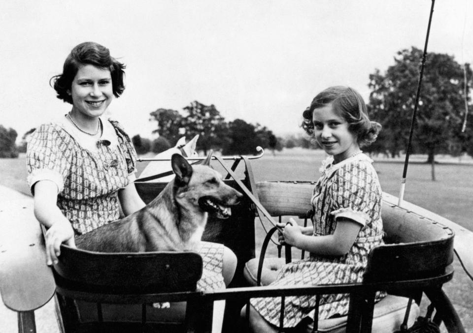 <p>Princess Elizabeth and Princess Margaret ride a ponycart in the garden of their wartime country residence (Windsor) (PA Archive) </p>