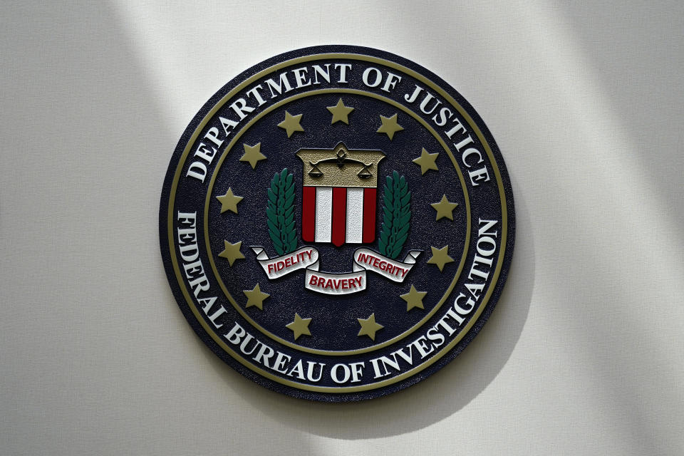 FILE - The FBI seal is pictured in Omaha, Neb., Aug. 10, 2022. Growing anger at the FBI from both parties in Congress has become a major hurdle for U.S. intelligence agencies fighting to keep their vast powers to collect foreign communications that often sweep up the phone calls and emails of Americans. (AP Photo/Charlie Neibergall, File)