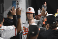 Baltimore Orioles' Ryan Mountcastle is greeted by teammates after hitting a solo home run against Texas Rangers starting pitcher Glenn Otto during the fifth inning of a baseball game, Thursday, Sept. 23, 2021, in Baltimore. (AP Photo/Terrance Williams)