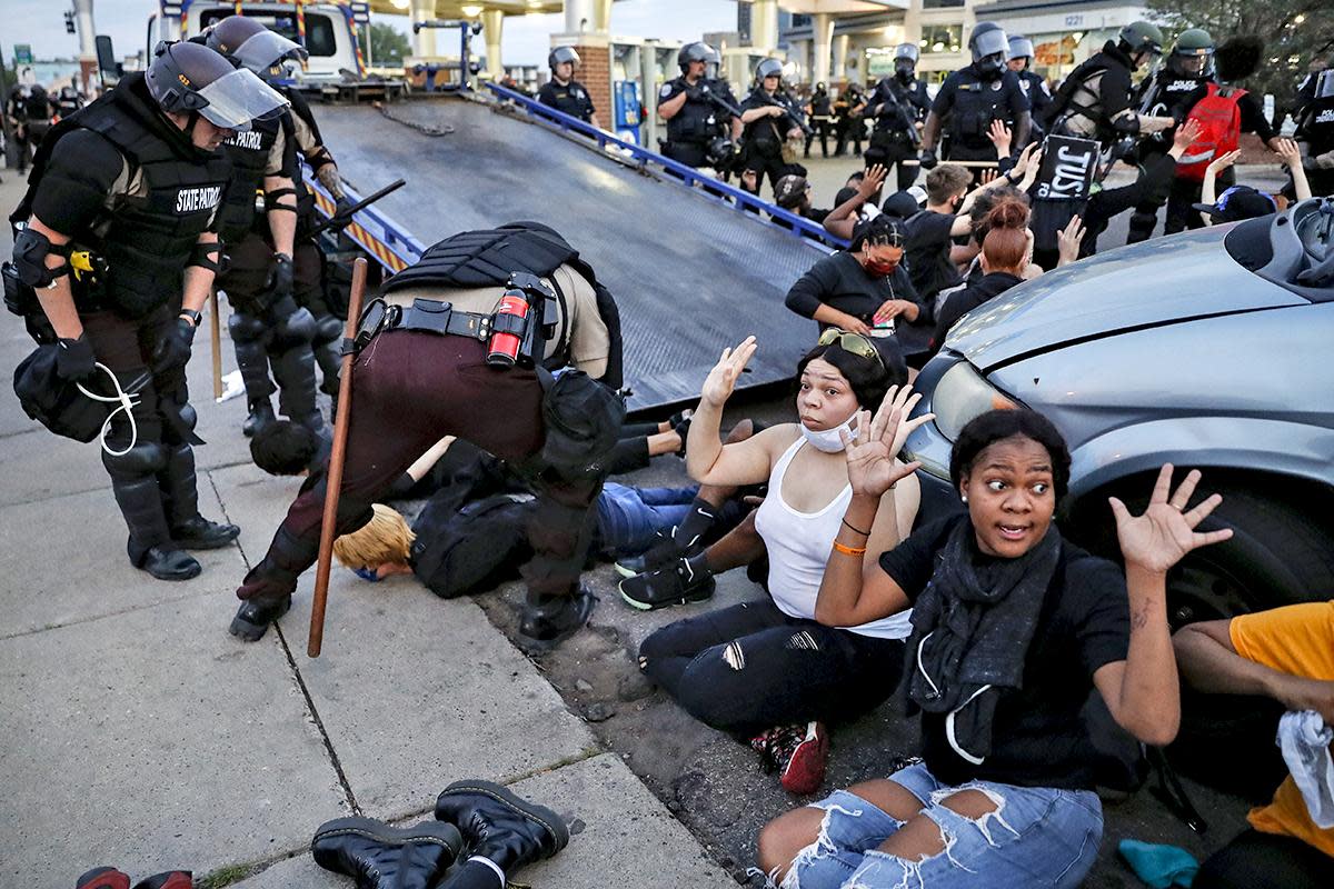 Protesters raise their hands on command from police as they are detained prior to arrest and processing at a gas station on South Washington Street, Sunday, May 31, 2020, in Minneapolis: AP