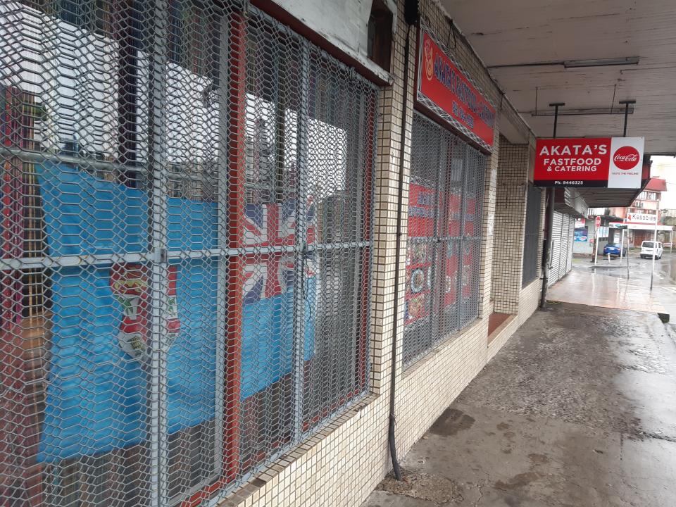 A fast-food store is closed in the preparation for cyclone Yasa in the Samabula neighborhood of Suva, Fiji, Thursday, Dec. 17, 2020. Fiji was urging people near the coast to move to higher ground Thursday ahead of a nationwide curfew as the island nation prepared for a major cyclone to hit.(AP Photo/Aileen Torres-Bennett)