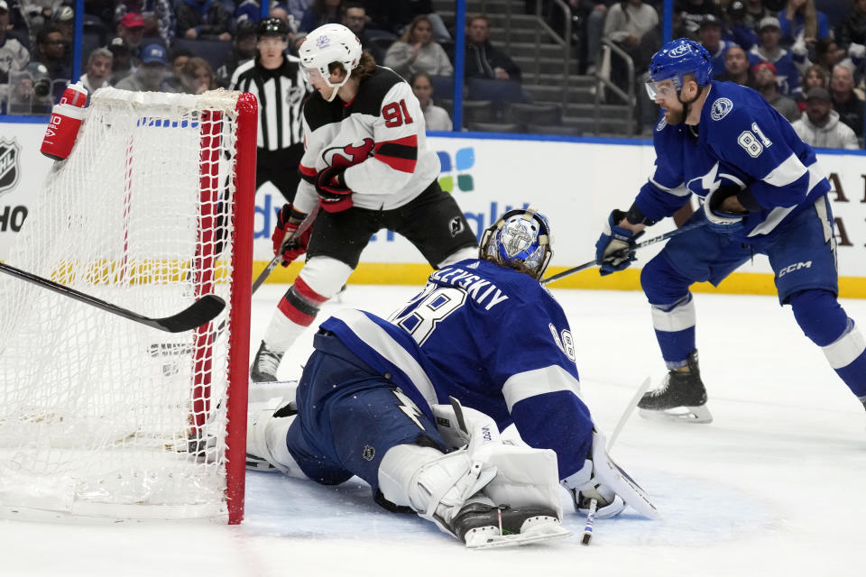 New Jersey Devils center Dawson Mercer (91) prepares to score past Tampa Bay Lightning goaltender Andrei Vasilevskiy (88) and defenseman Erik Cernak (81) during the first period of an NHL hockey game Thursday, Jan. 11, 2024, in Tampa, Fla. (AP Photo/Chris O'Meara)