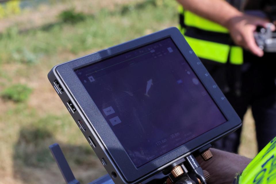 A firefighter looks at the screen as drone flying above the Seine monitors the whale's movements (REUTERS)