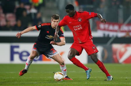 Football Soccer - FC Midtjylland v Manchester United - UEFA Europa League Round of 32 First Leg - MCH Arena, Herning, Denmark - 18/2/16 FC Midtjylland's Paul Onuachu and Manchester United's Paddy McNair Action Images via Reuters / Paul Childs Livepic EDITORIAL USE ONLY.