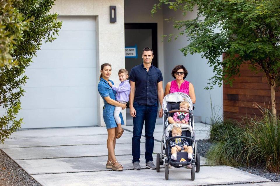 The Coyne family stands in the driveway of the Coconut Grove townhouse they paid a $500,000 deposit for in 2021. Now it’s for sale at double the price they signed for. From left to right, Oksana, Nathan, Mike, Liudmyla Vovk, Madison, and Valerie Coyne.