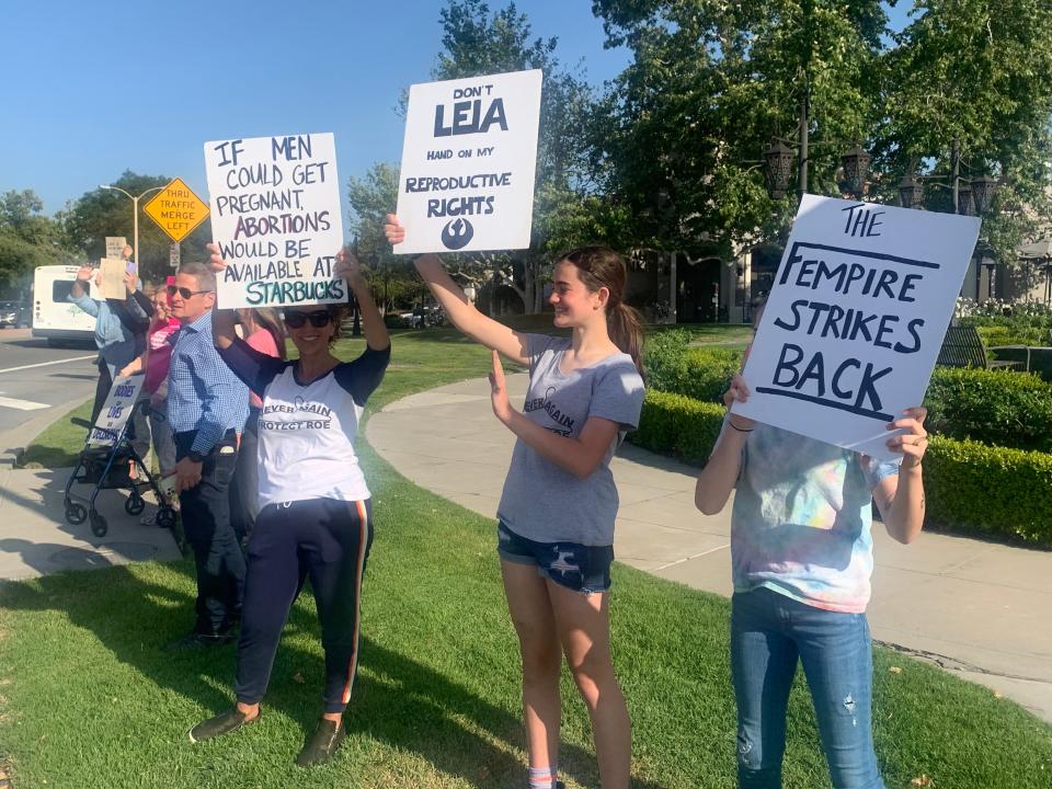 Demonstrators hoisted signs at the corner of Thousand Oaks and Westlake boulevards Tuesday evening in support of abortion rights.