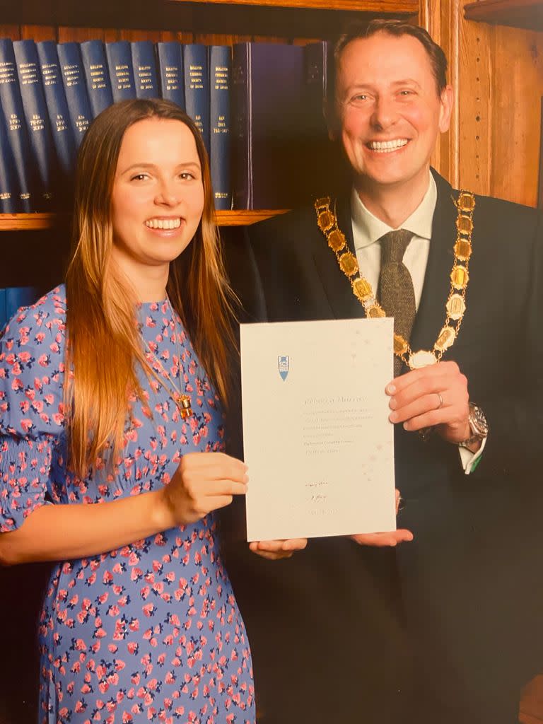 Young woman holding her university diploma