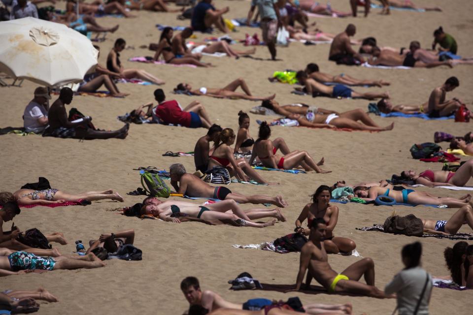 Numerosas personas toman un baño de sol en una playa en Barcelona. (AP Foto/Emilio Morenatti)