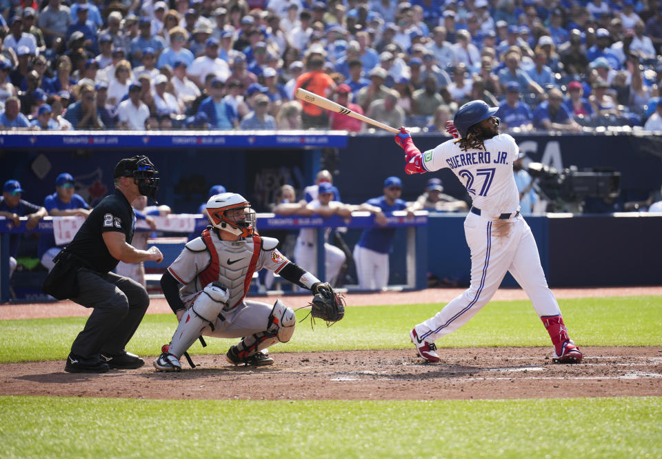 Toronto Blue Jays' Vladimir Guerrero Jr. (27) hits a RBI single against the Baltimore Orioles during the sixth inning of a baseball game in Toronto, Thursday Aug. 3, 2023. (Mark Blinch/The Canadian Press via AP)