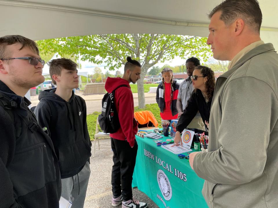 Nate Corder, membership development coordinator for IBEW Local 1105, talks with Newark students Gabe Beane and Paul Negele about future opportunities as electricians during a skilled trades celebration.