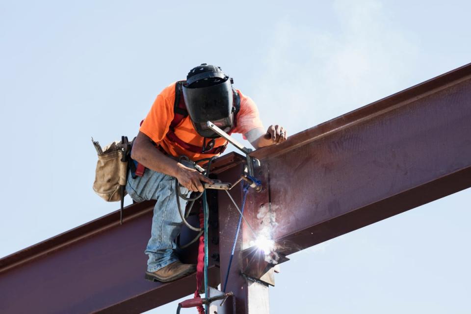 A person welding a steel girder. 