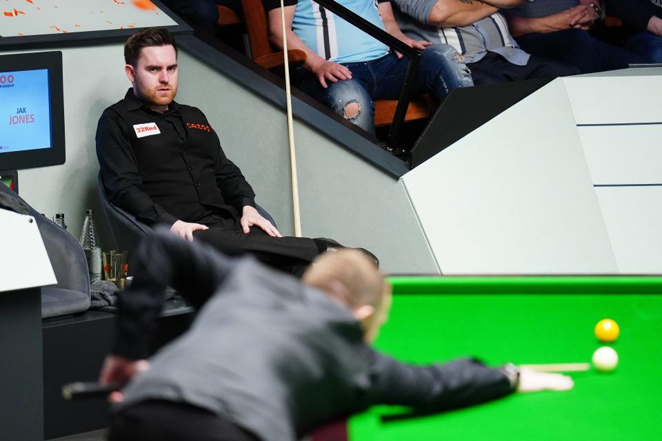 Jak Jones watches on as Mark Allen takes to the table (PA)