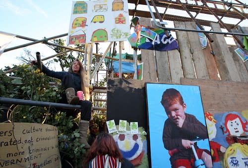 A woman looks out from the front gate at Dale Farm travellers' site at Cray's Hill, near Basildon, Essex