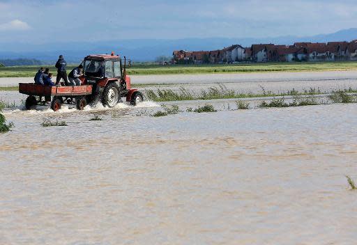 Un tractor recorre un campo inundado en la localidad bosnia de Bijeljina el 17 de mayo de 2014 (AFP | -)