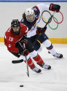 Meghan Duggan of the United States and Brianne Jenner of Canada races after the puck during the second period of the 2014 Winter Olympics women's ice hockey game at Shayba Arena, Wednesday, Feb. 12, 2014, in Sochi, Russia. (AP Photo/Petr David Josek)